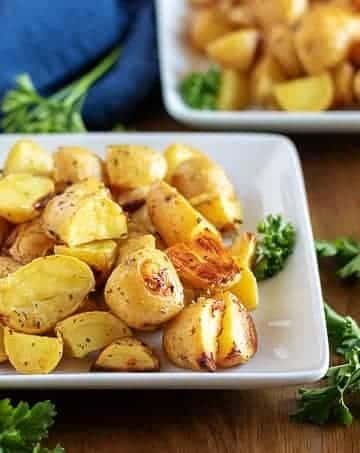 The ranch potatoes, garnished with parsley, sitting in a square dish.