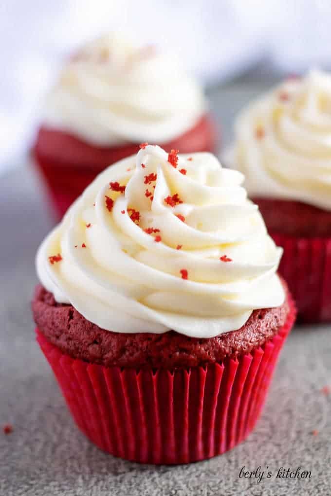 Close-up shot of a finished red velvet cupcake with cream cheese frosting.
