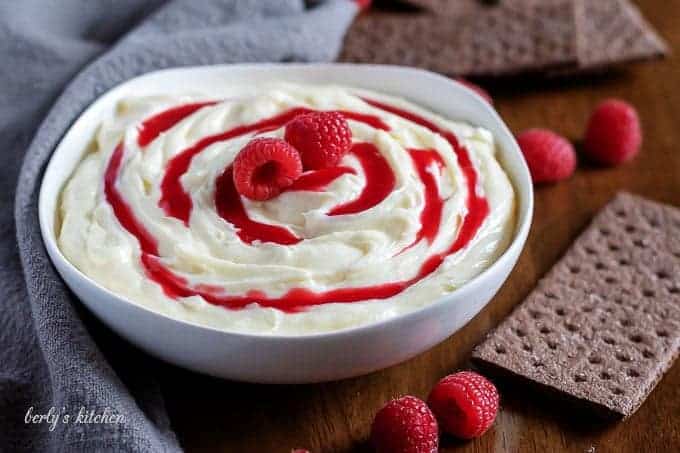 The white chocolate raspberry cheesecake dip topped with sauce and fresh berries.