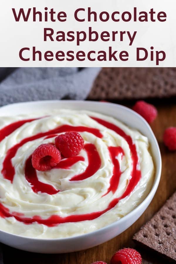 The white chocolate raspberry cheesecake dip in a bowl with berries.