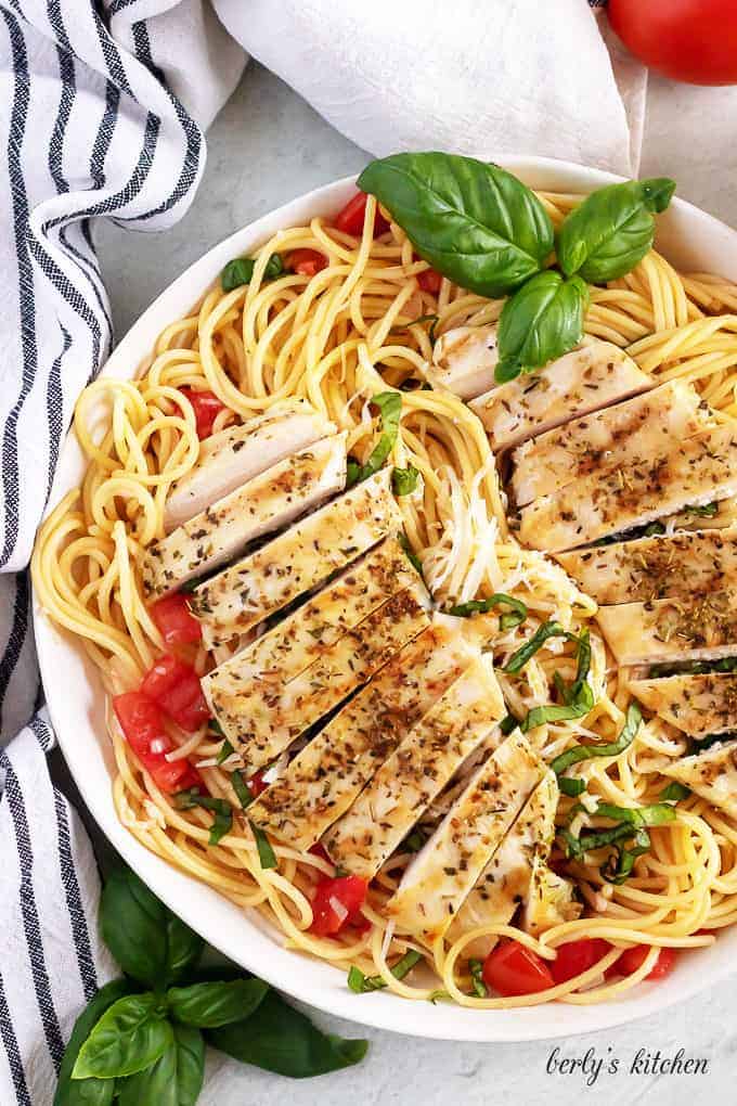 Aerial view of the chicken pasta, topped with fresh basil and parmesan.