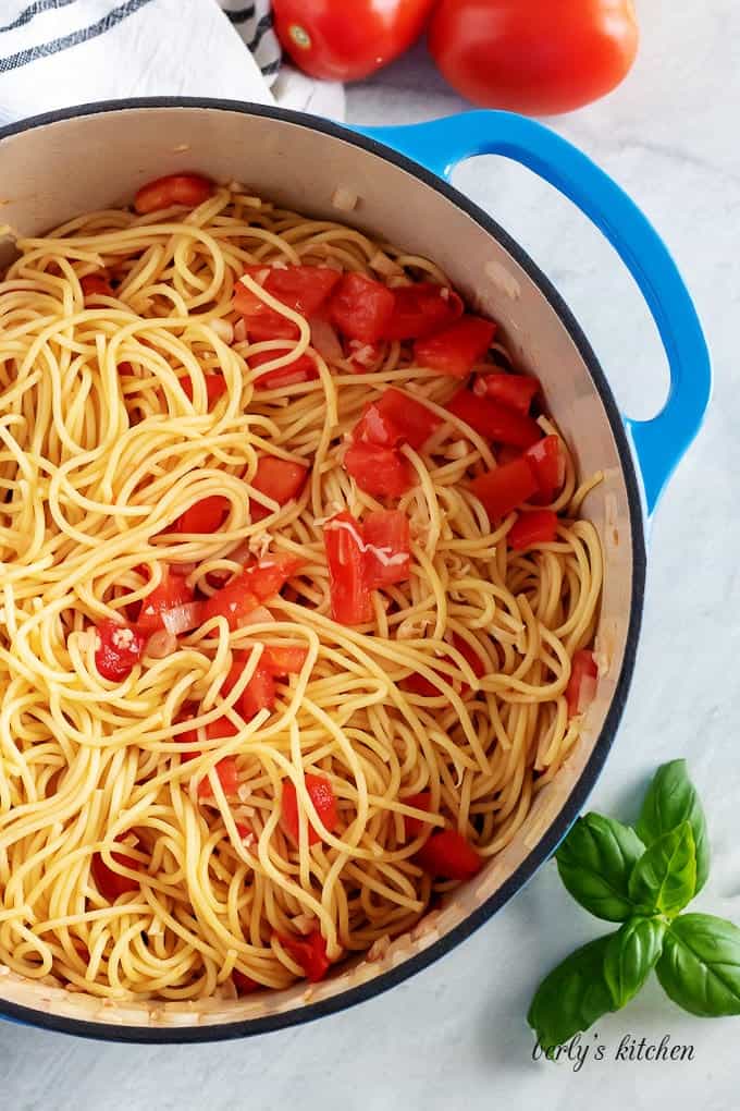 Top-down view of the pasta noodles, tossed with tomatoes and oil.