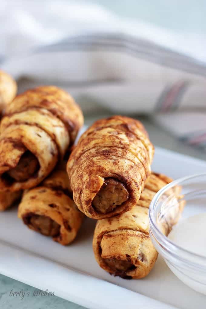 The cinnamon sausage pigs in a blanket sitting on a serving platter.