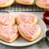 Cut out sugar cookies with cookie cutters on a plate.