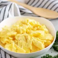 A final shot of the fluffy scrambled eggs in a white bowl.