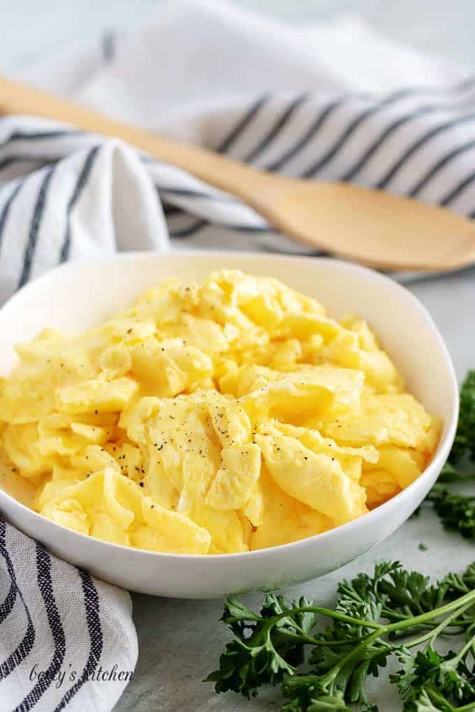 A final shot of the fluffy scrambled eggs in a white bowl.