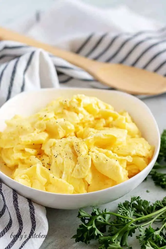 A final shot of the fluffy scrambled eggs in a white bowl.
