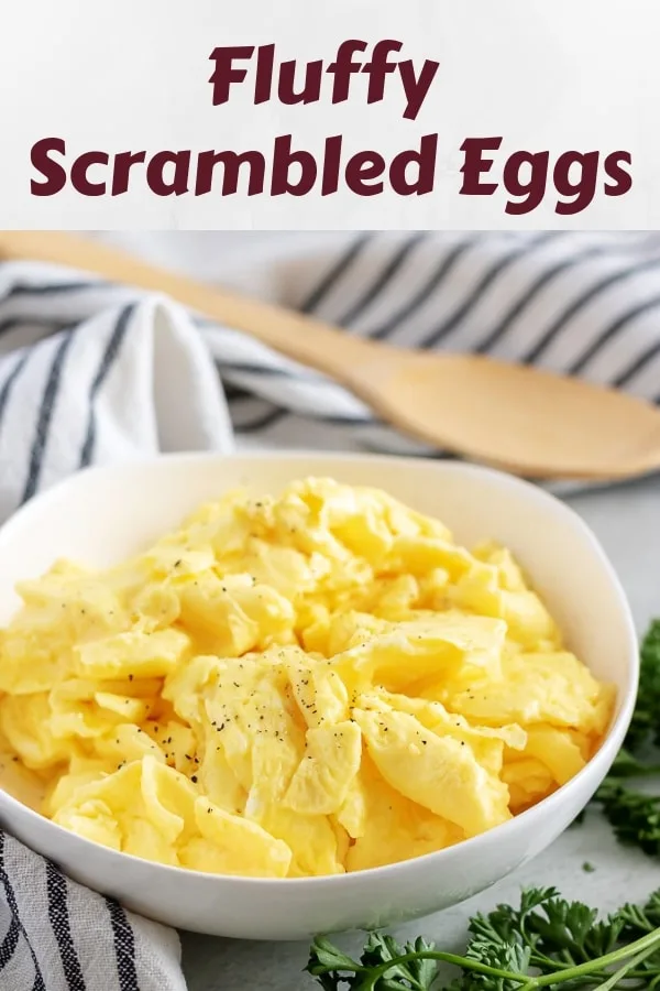 The fluffy scrambled eggs, in a bowl, dusted with black pepper.