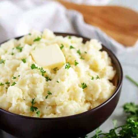 Garlic Mashed Potatoes Recipe Final shot of the garlic mashed potatoes in a bowl, with butter and parsley.
