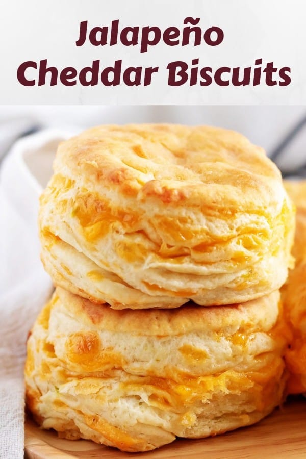 Two stacked cheddar biscuits, accented with a napkin, layered with cheddar cheese.