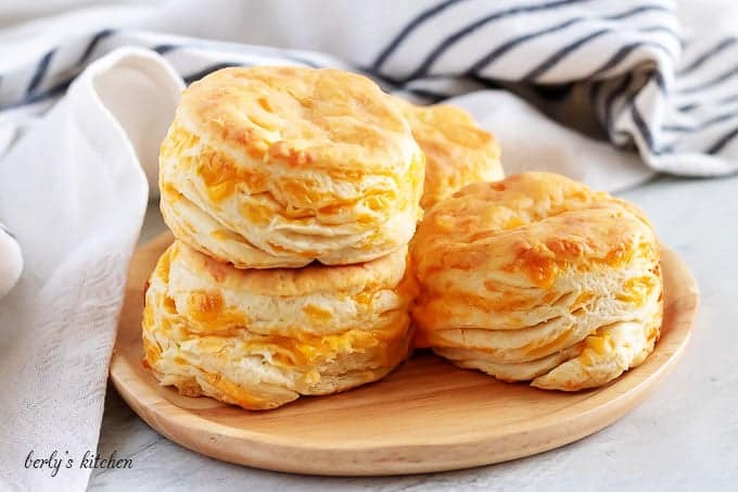 Four golden brown jalapeno cheddar biscuits stacked, in twos, on a plate.