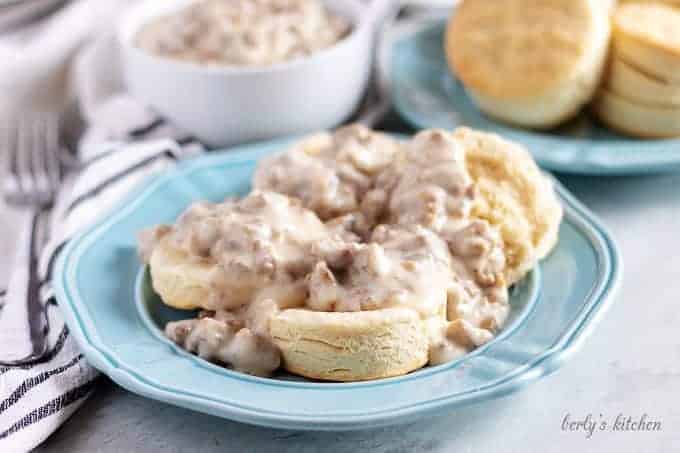 The sausage gravy has been poured over two homemade biscuits.