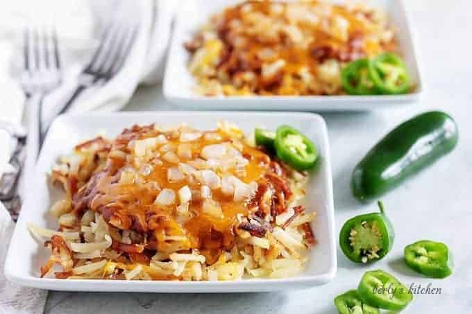Two servings of shredded hash browns, topped with chili, cheese, and onions.