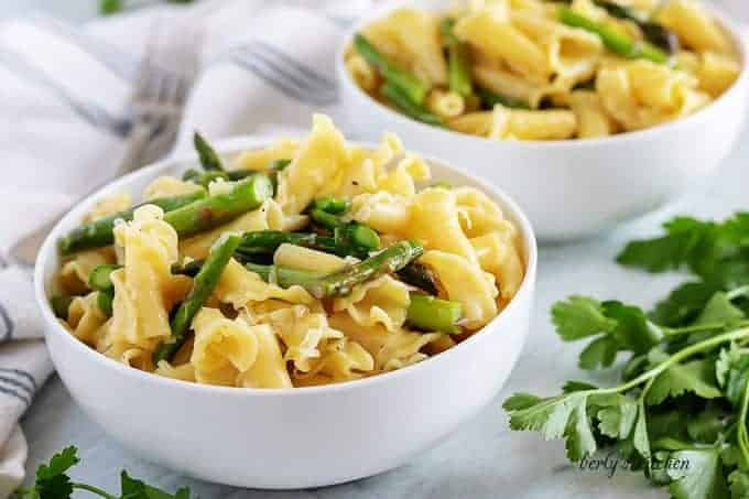 Two bowls asparagus pasta topped with fresh grated Parmesan cheese.