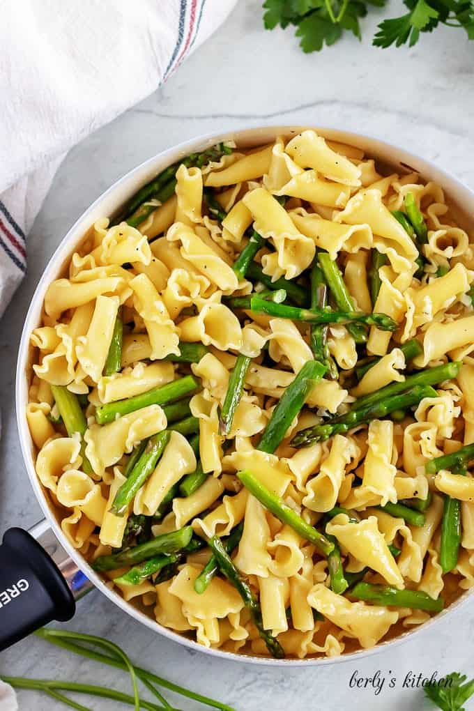 Pasta has been added to the asparagus and is ready for tossing.