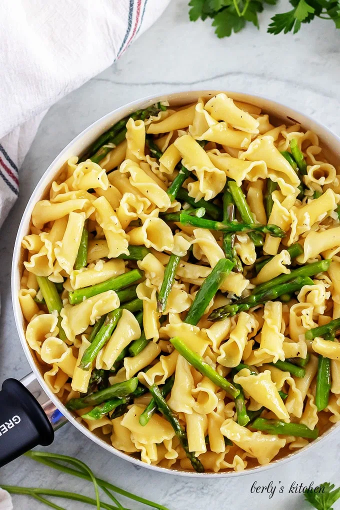 Pasta has been added to the asparagus and is ready for tossing.