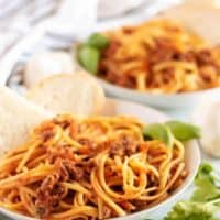 Final large photo of the beef bolognese served with fresh baked bread.