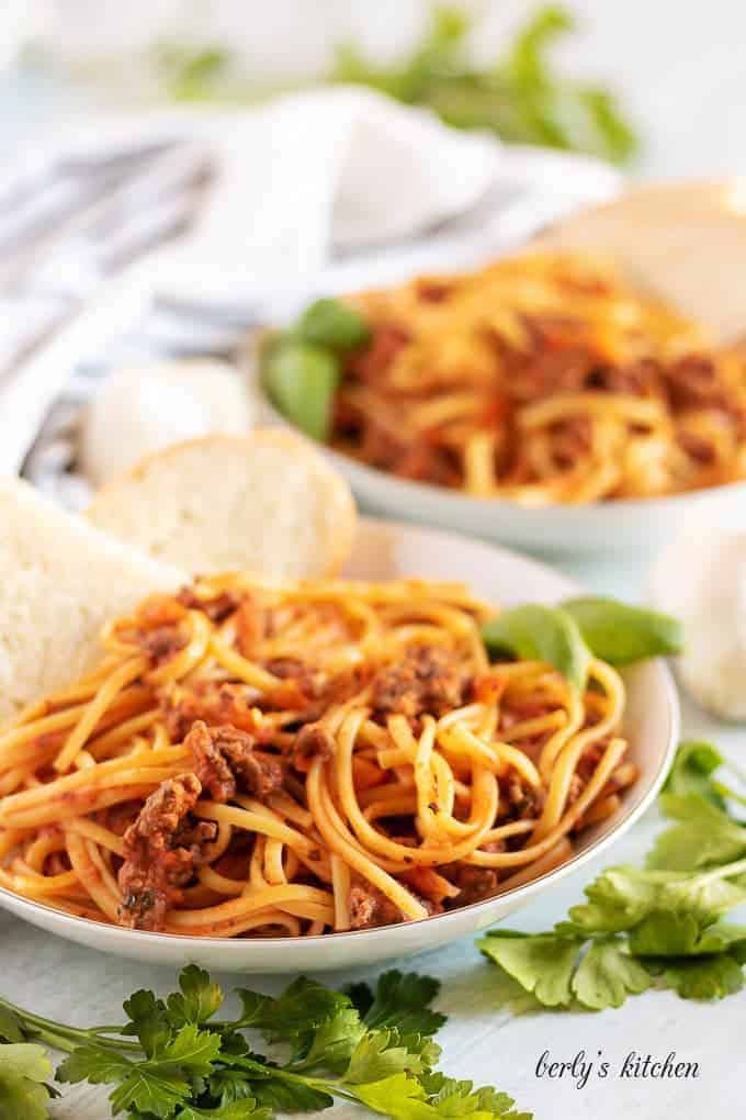 Final large photo of the beef bolognese served with fresh baked bread.