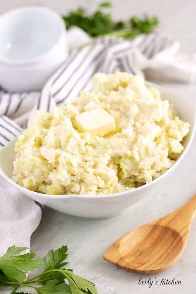 The colcannon has been placed in a bowl and garnished with butter.