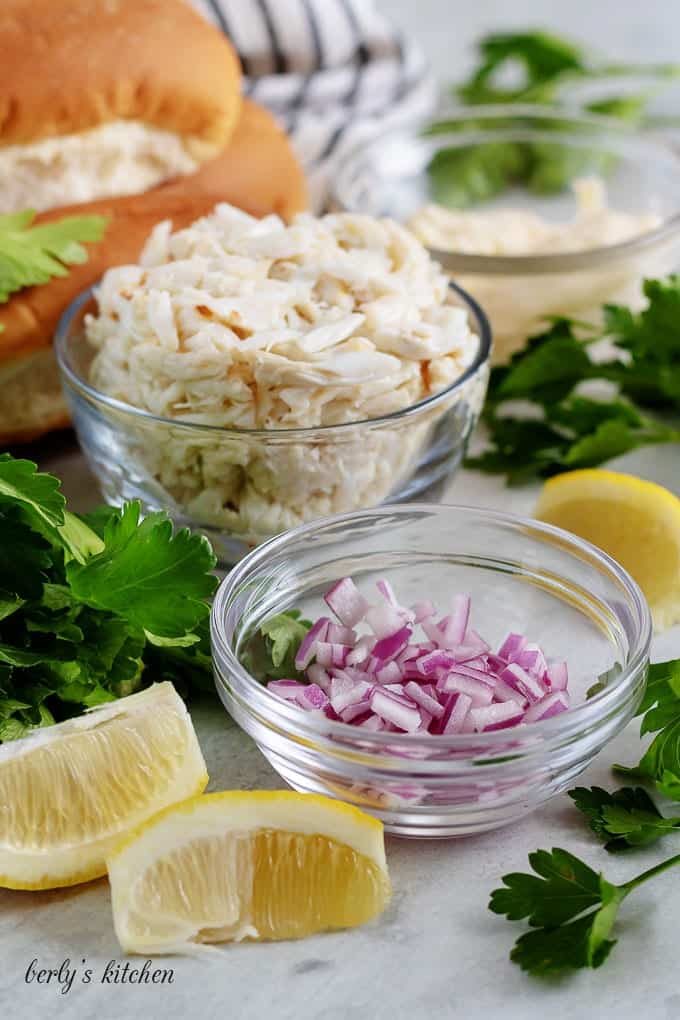 The crab roll recipe ingredients like red onions, crab meat, and buns.