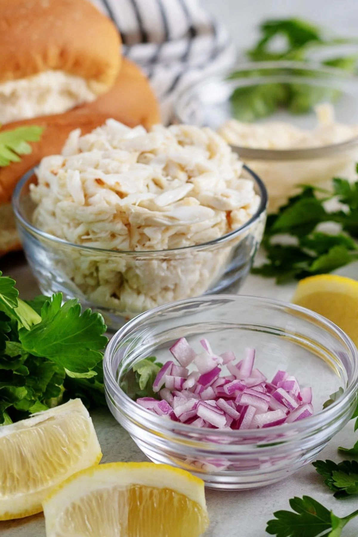 The crab roll recipe ingredients like red onions, crab meat, and buns.