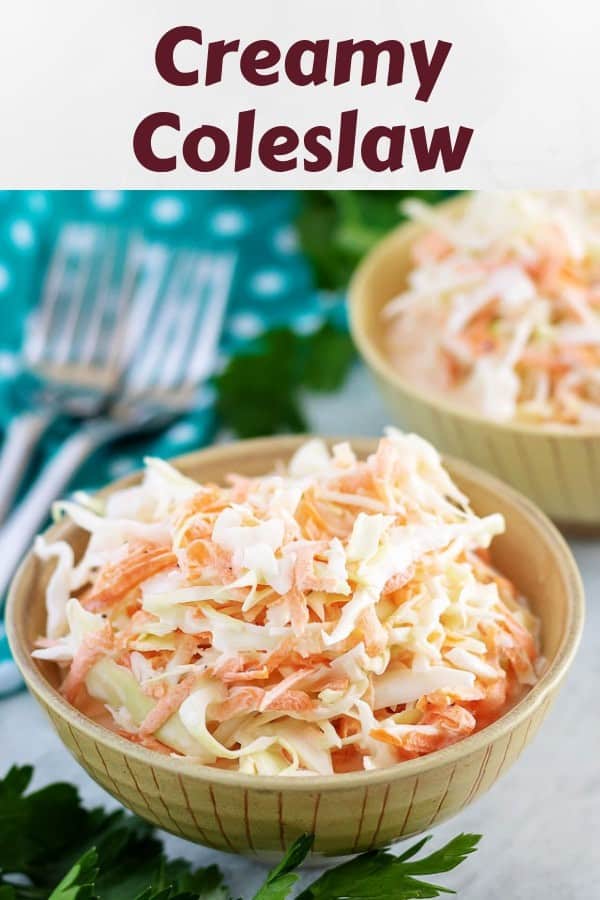 Two small bowls of creamy coleslaw with forks sitting nearby.