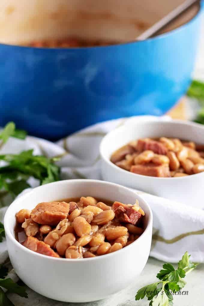 Two big bowls of ham and beans sitting on a towel.