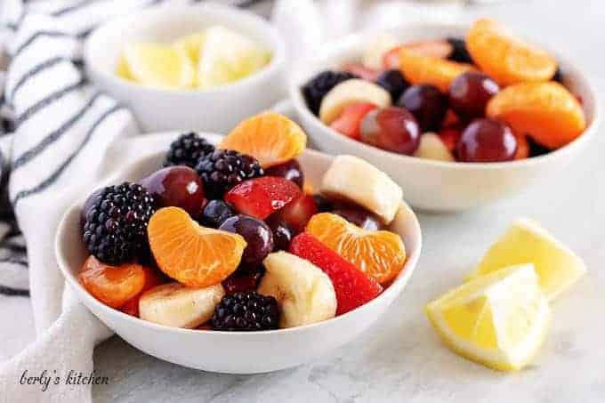 Two bowls of homemade fruit salad tossed with lemon syrup.