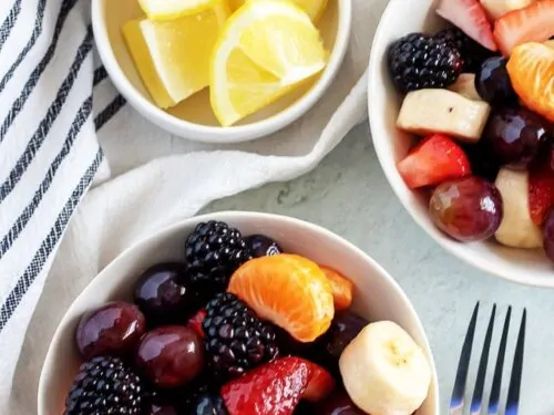 An aerial photo of two bowls filled with homemade fruit salad.