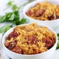 The finished kielbasa and sauerkraut served in two bowls with parsley.