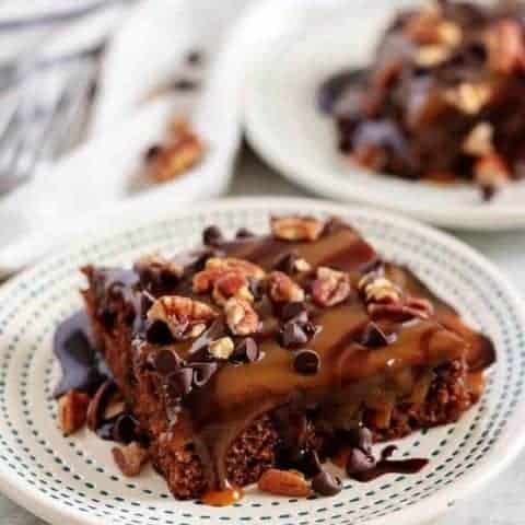 Brownie Mix Turtle Brownies Two big squares of turtle brownies served on white plates.