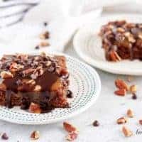 Two turtle brownies covered in chocolate ganache and sweet caramel.