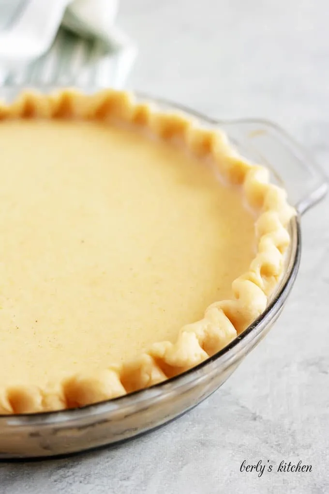 The buttermilk pie filling has been poured into the unbaked crust.