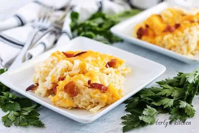 Two servings of the hash brown casserole recipe sitting on white plates.