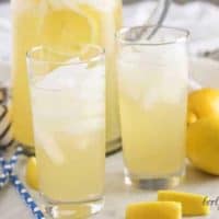A pitcher and two glasses filled with ice and Instant Pot lemonade.