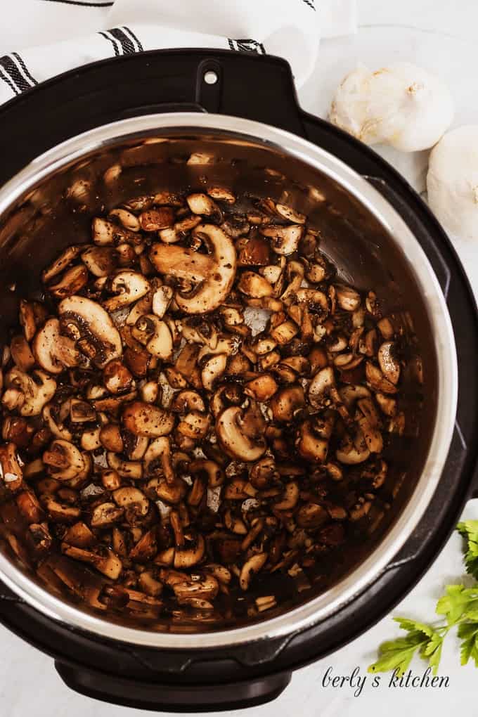 An aerial view of the mushrooms and onions in the instant pot.