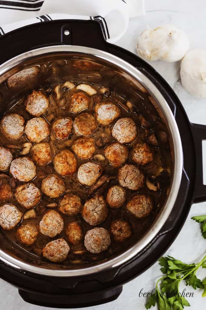 The meatballs have been added and they pot is ready for sealing.