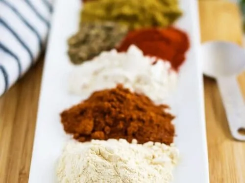 The individual spices measured out on a long rectangular plate.