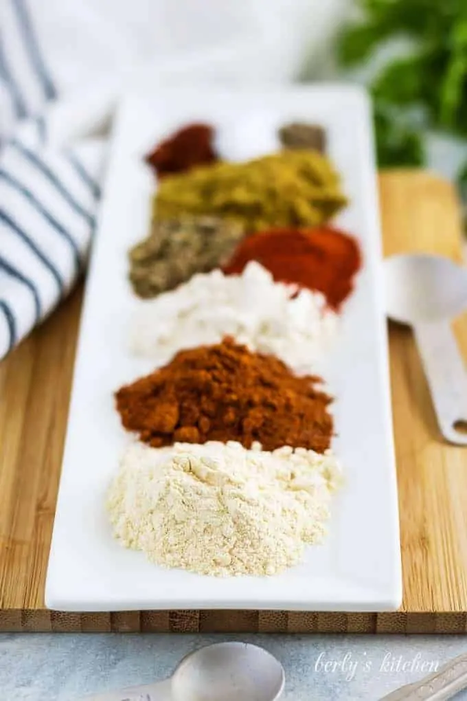 The individual spices measured out on a long rectangular plate.