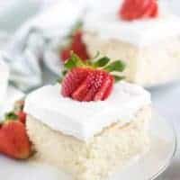 A slice of tres leches cake sitting on a white saucer.