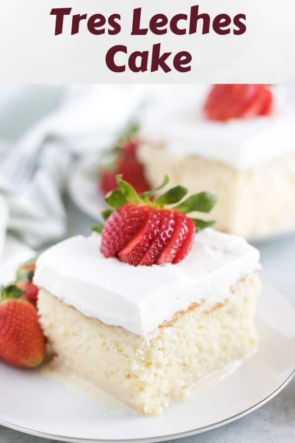 A piece of tres leches cake garnished with a strawberry.