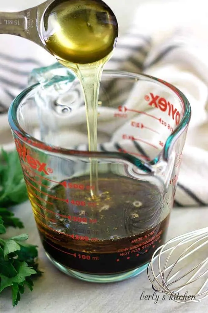 A tablespoon of honey being added to the soy sauce.