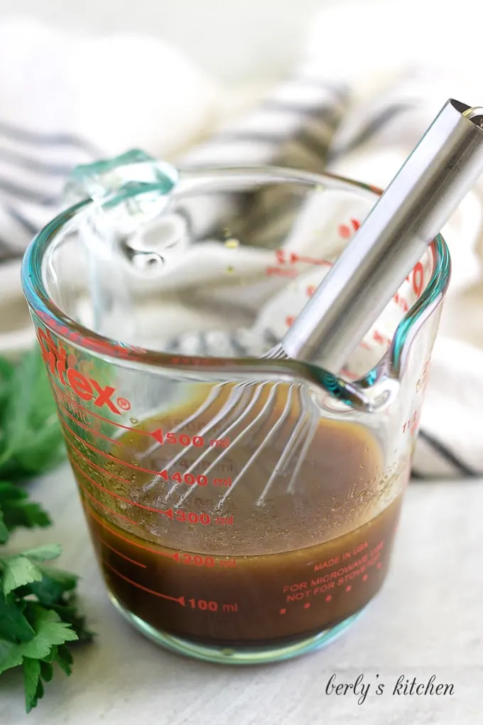 Sesame oil and other ingredients whisked together in a measuring cup.