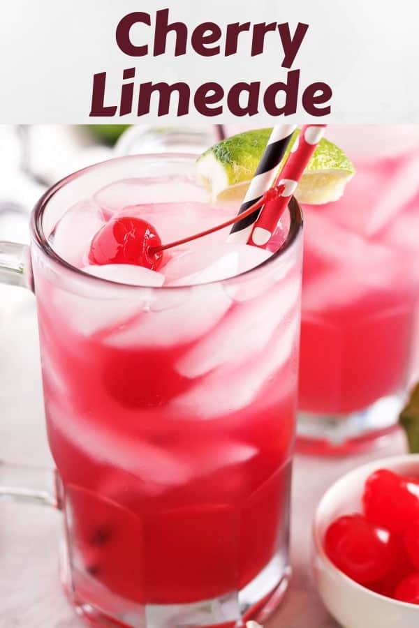 A cherry limeade served in a glass mug, garnished with a cherry.