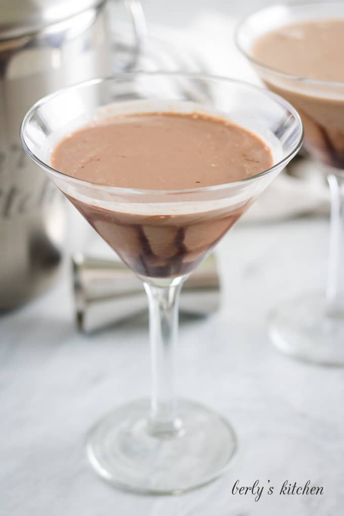 Two chocolate martinis in martini glasses on a marble table top.
