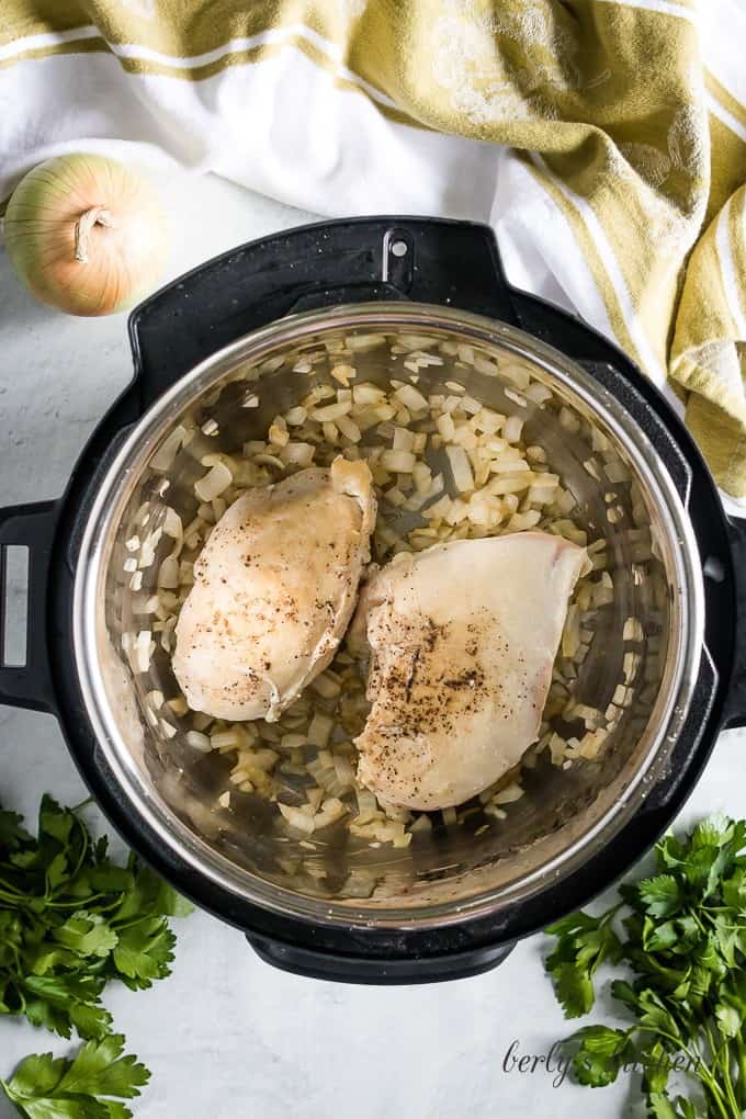 Aerial view of the chicken breast browning in the pressure cooker.