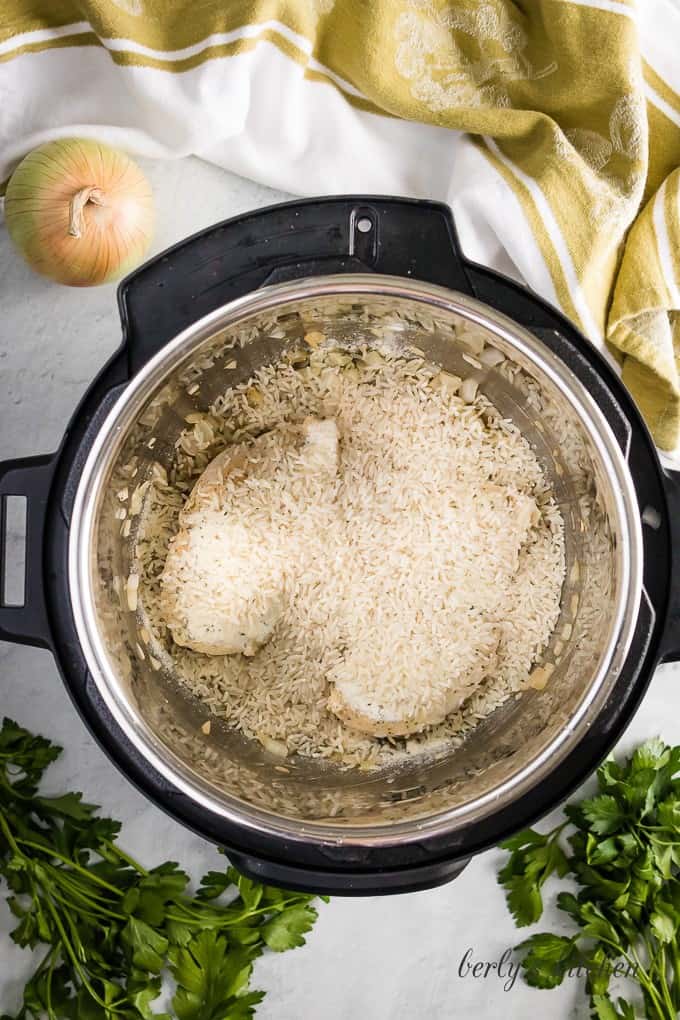 The uncooked rice has been added to the pressure cooker.