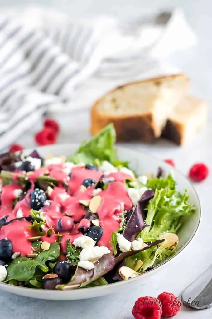The salad dressing over a of Spring mix topped with feta cheese.