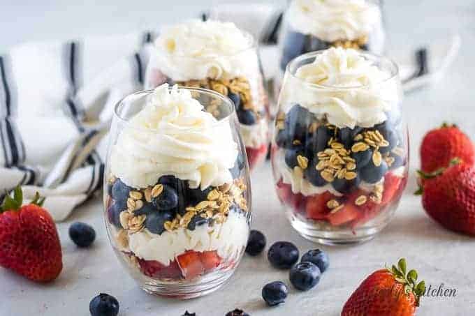 Four of the fruit parfaits served in stemless wine glasses.