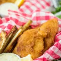 Fried fish, in a basket, served with fries and tartar sauce.